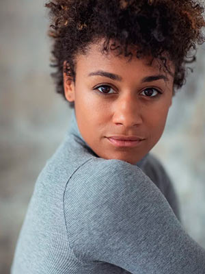 Ариана ДеБоуз в роли Люси Фаринелли-Уотсон